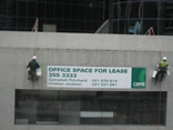 professional industrial abseilers putting up high rise advertising banner